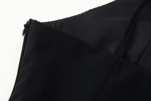 Detailed macro view of the invisible zipper and black fabric texture on the dress