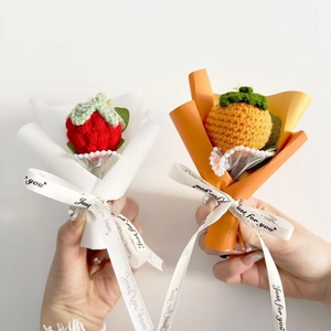 Mini hand-knitted flower bouquet with strawberry and persimmon shapes in gift wrap