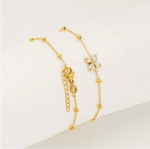 Detail view of gold clover bracelet with lobster clasp and adjustable extension chain
