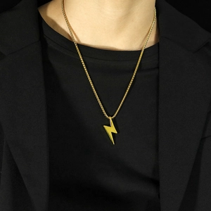 Gros plan d'un collier pendentif éclair doré porté sur le cou sur fond noir élégant