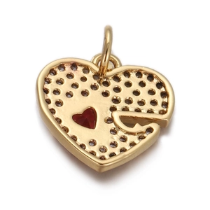 Detailed close-up of golden heart pendant with hollow patterns and red inlay decoration
