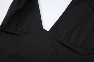 Detail of black deep V-neck top showing pleated fabric and high-stretch knit texture