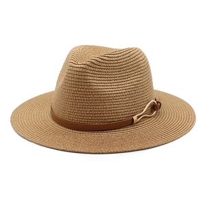 Detail view of woven brown straw Panama hat with a leather band and gold metal buckle