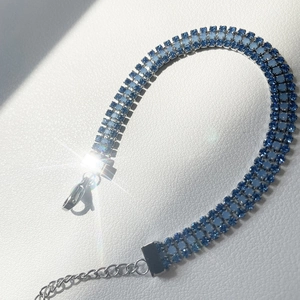 Detail of three-row blue crystal bracelet with silver chain and starburst shine effect