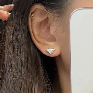 Sterling silver triangle stud and gold CC logo ear cuff worn on ear model
