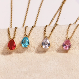 Detail of four stainless steel gold necklaces with colorful pear-cut zircon pendants