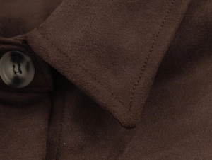 Detail of dark brown suede jacket showing lapel stitching and marble texture button