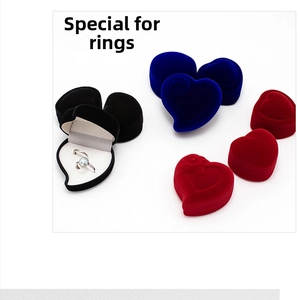 Macro detail of heart-shaped velvet ring boxes with rose relief and inner padding