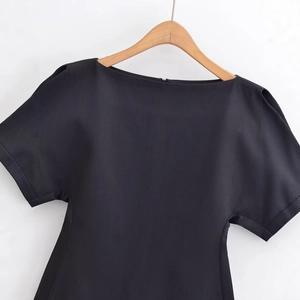 Haut noir à manches bouffantes pour femmes sur cintre en bois avec col élégant