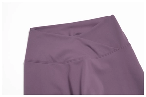 Close-up of purple yoga leggings featuring a V-shaped cross waist and flat stitching