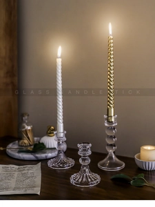 Dettaglio di eleganti candelieri in vetro trasparente con texture su tavolo in legno