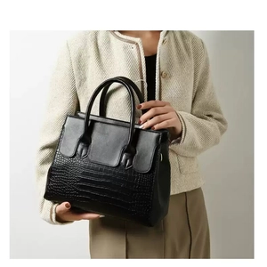 Close-up of black crocodile pattern leather tote with reinforced handles and textures