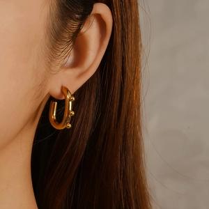 Elegant 18K gold plated titanium steel oval U-shaped hoop earrings on female model