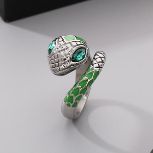 Macro view of silver snake ring with green rhinestone eyes and detailed emerald enamel scales