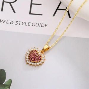 Détail macro du collier cœur doré avec zircons rouges et cristaux blancs pavés