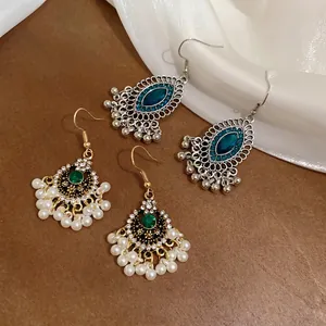 Orecchini vintage con perle e cristalli su superficie in pelle scura