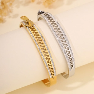 Detailed macro of gold and silver zipper-style bangles with inset rhinestones