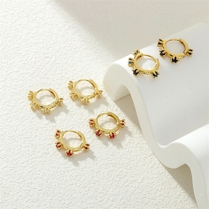 Detailed view of three pairs of 18K gold plated hoop earrings with zircon floral accents
