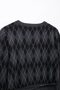 Close-up of diamond pattern knitting texture and neckline on black and gray sweater