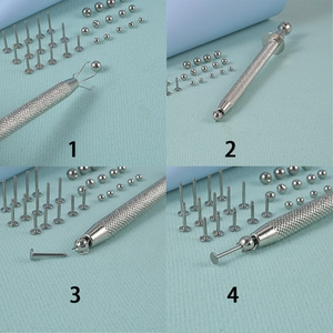 Macro view of 4-prong pickup tool grabbing small beads and stainless piercing jewelry