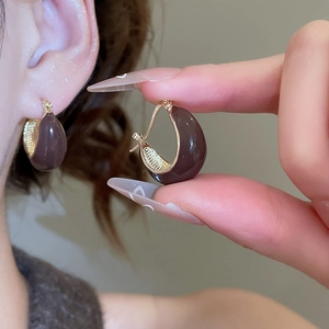 Detail of vintage teardrop earrings in brown and gold acrylic and wood design