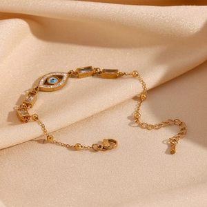Detail of 18K gold plated bracelet with evil eye charm and clear zircon stones on satin