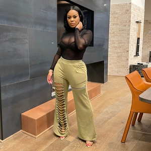 Women's black sheer mesh top and olive green wide-leg pants with cutout detail
