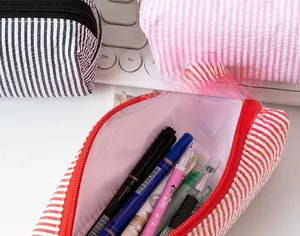 Detail showing high-capacity seersucker pencil case with classic striped pattern