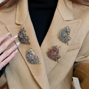 Hollow unicorn brooch set with rhinestones worn on camel wool coat lapel for women