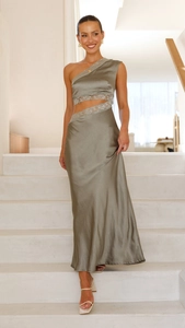 Détail d'une robe longue en satin vert sauge avec découpe à la taille et dentelle