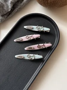 Detail of four-piece dog hair clips set with egg lettering in blue and pink tones