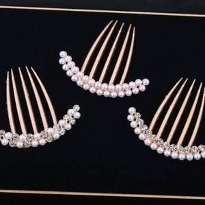 Elegant rose gold hair comb set with pearls and crystals on a black velvet display