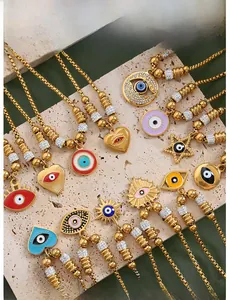 Macro view of gold-plated evil eye charms with colorful enamel and zircon on a stone board
