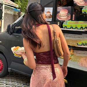Detail of burgundy lace halter top with long silk ribbons and backless design