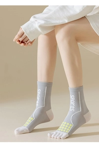 Detail of gray five-finger sports socks with neon green non-slip dots and knit texture
