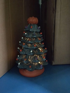 Detail of a black Halloween ceramic tree with glowing orange and purple festive lights