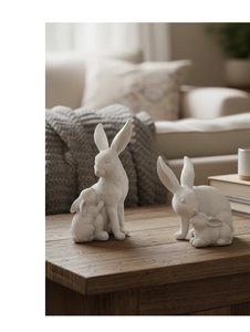Gros plan de figurines de lapins en résine blanche sur table en bois pour décoration