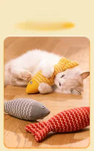 Katze spielt mit gelbem Canvas-Fischspielzeug mit Katzenminze auf Holzboden