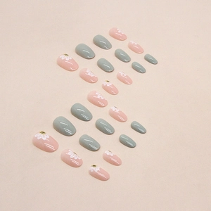 Short oval press-on nails in light green and pink with white daisy floral designs