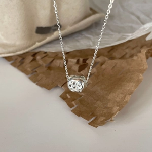 Detail of a 925 sterling silver necklace featuring an irregular stone-shaped pendant