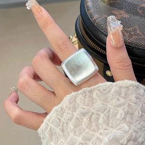 Detail view of square silver ring with brushed metal texture and minimalist matte finish