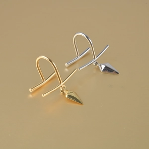 Macro detail of U-shaped non-piercing lip rings with gold and silver spike pendants