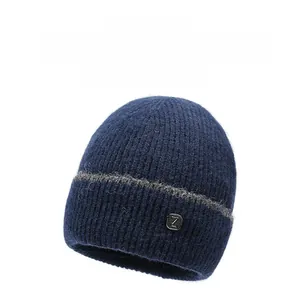 Dettaglio di un berretto invernale in maglia blu scuro con trama e patch logo.