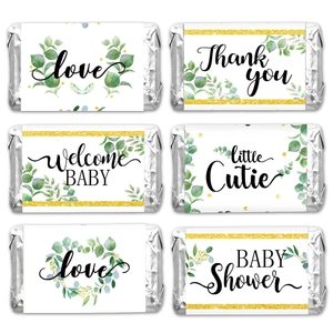 Detail of candy bar wrappers with greenery designs and gold frames for baby showers