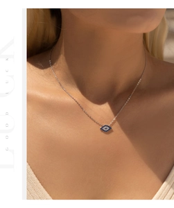 Close-up of S925 sterling silver evil eye pendant with blue zircon stones on a model