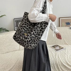 Detail of leopard print plush tote bag with gold logo on minimalist background