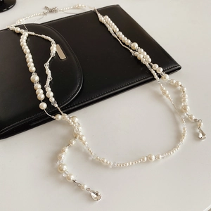 Détail du collier double rang avec perles blanches, perles cristal et pendentifs gouttes