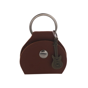 Close-up of brown leather guitar pick pouch with metal ring and guitar-shaped pendant