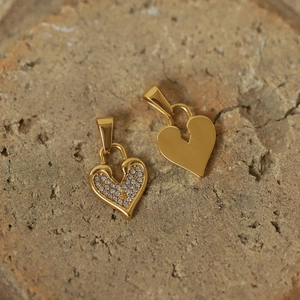 Detailed macro of vintage gold-plated titanium heart lock pendants with crystal inlay