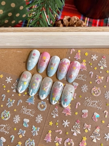 Detail of Christmas nail art stickers with snowflake patterns and pink gradient finish